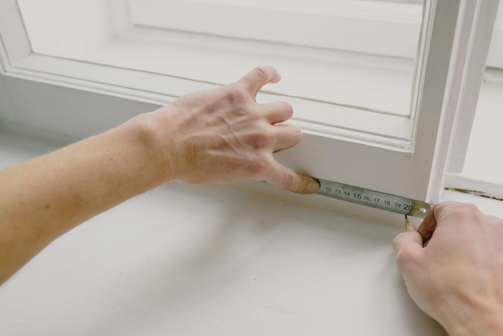 pexels photo 5691534 5691534 From above of crop anonymous workman measuring wooden window frame using metal ruler and pencil in house